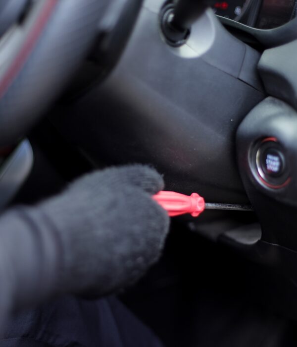 Close Up Of Professional Car Thief Hand Hacking Ignition Lock Using Screwdriver